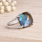 Sterling silver labradorite ring with a large faceted stone on wood