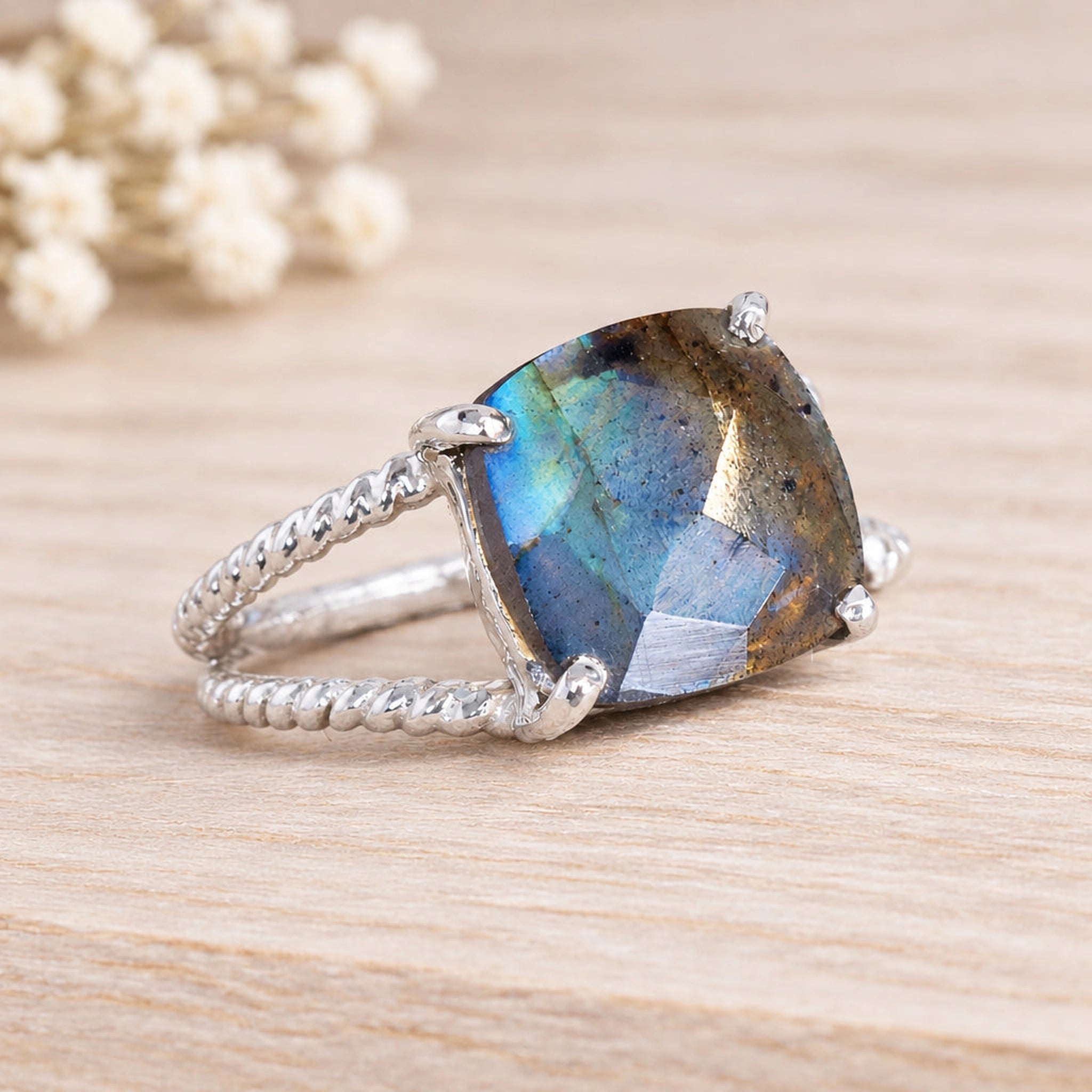 Sterling silver labradorite ring with a large faceted stone on wood