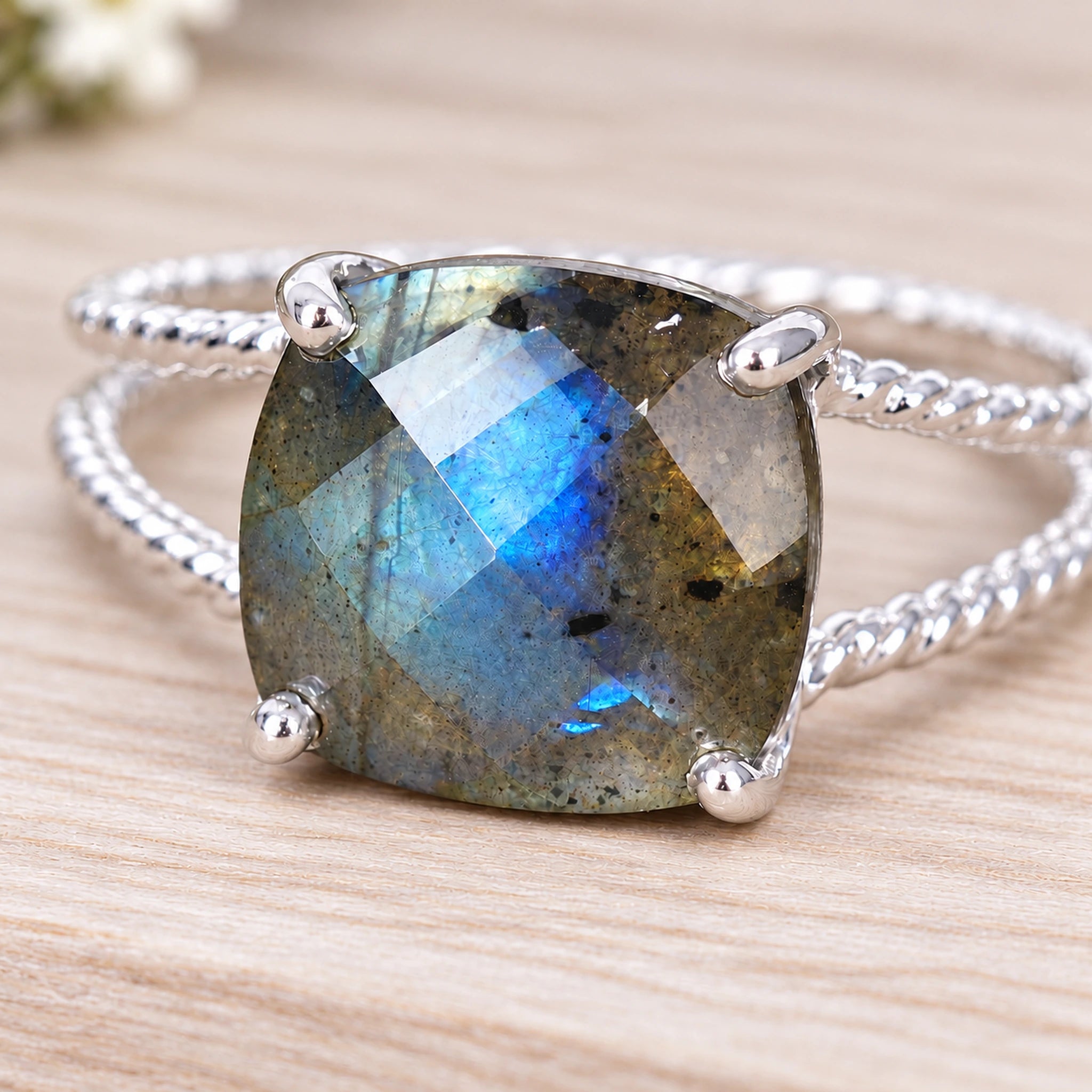 Silver ring with a large labradorite stone on wood