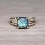 Sterling silver labradorite ring with blue green flash on wood