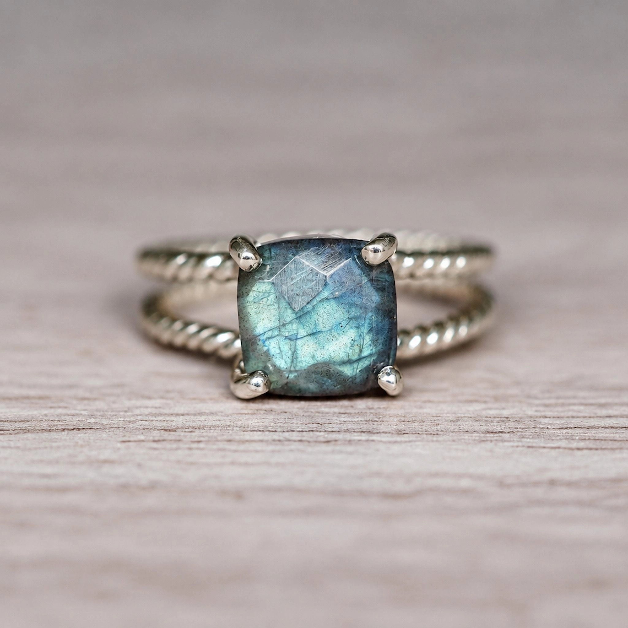 Sterling silver labradorite ring with blue green flash on wood