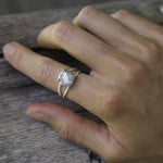 Hand wearing the sterling silver labradorite ring on wood