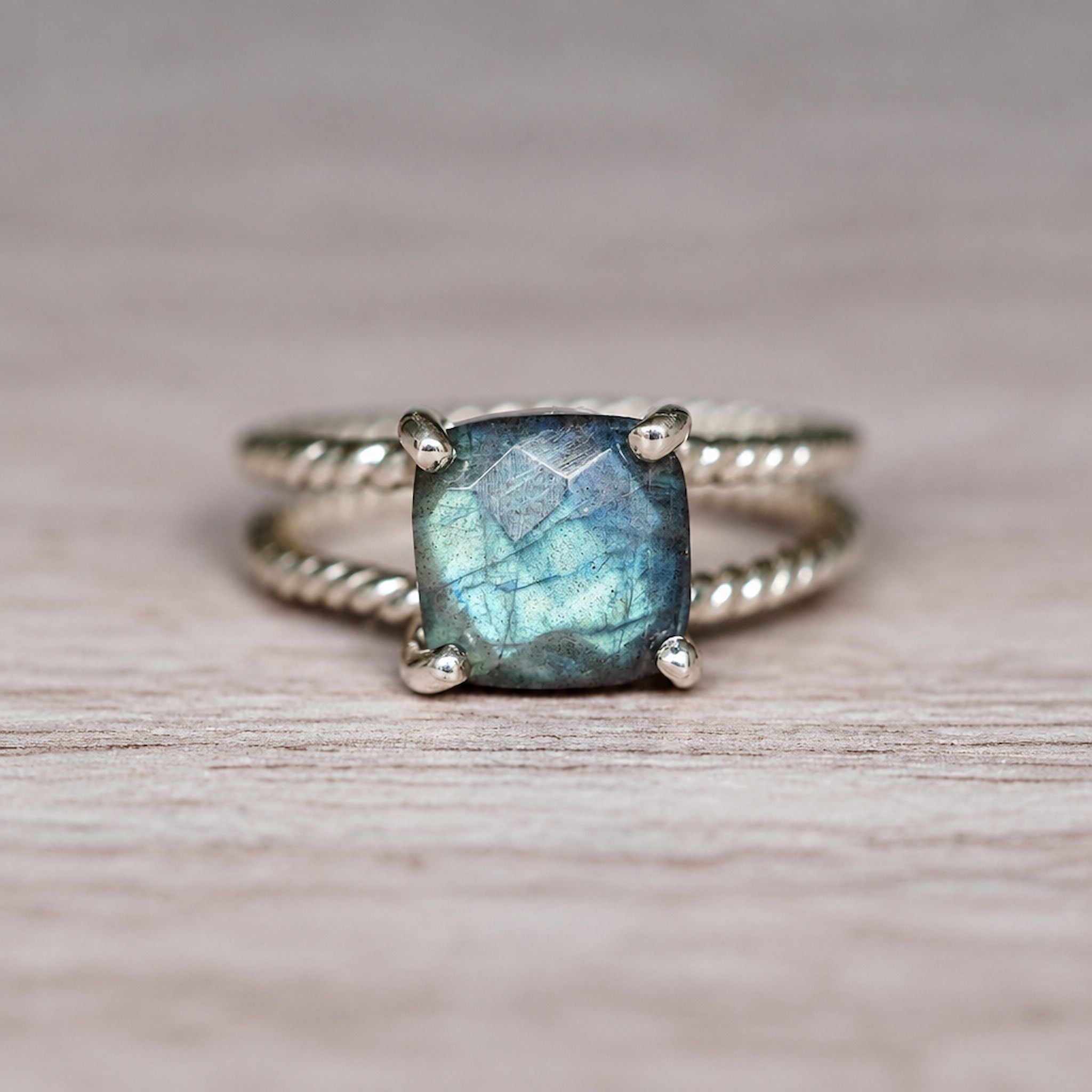 sterling Silver ring with a blue green natural labradorite gemstone on a wooden surface