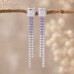 Pair of lilac CZ earrings on a branch with a blurred natural background