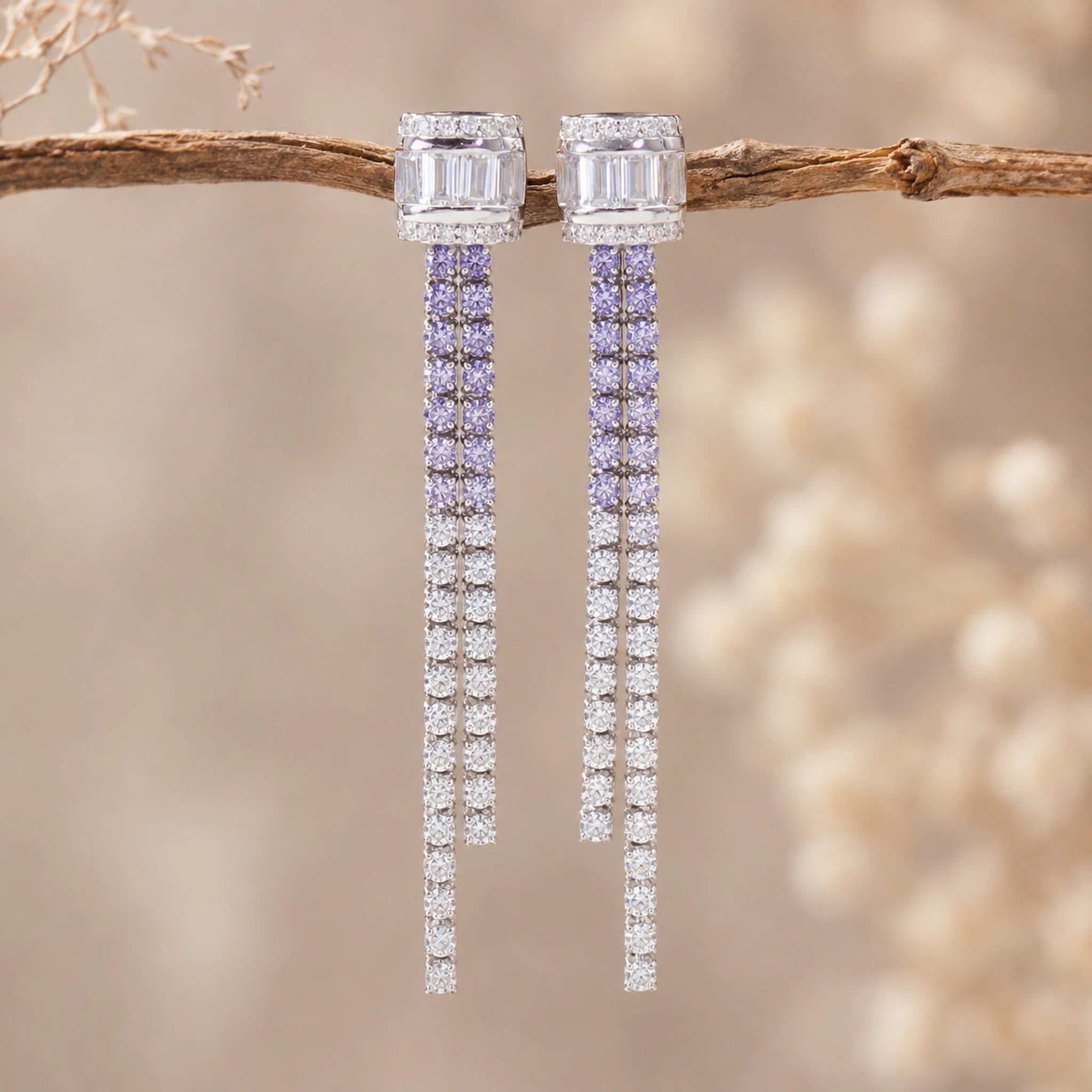 Pair of lilac CZ earrings on a branch with a blurred natural background