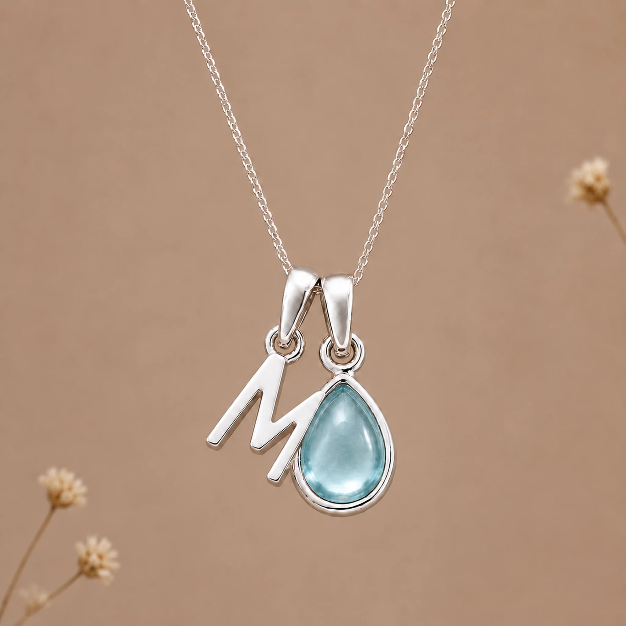 Sterling silver M initial necklace with pale blue March aquamarine in a polished teardrop bezel