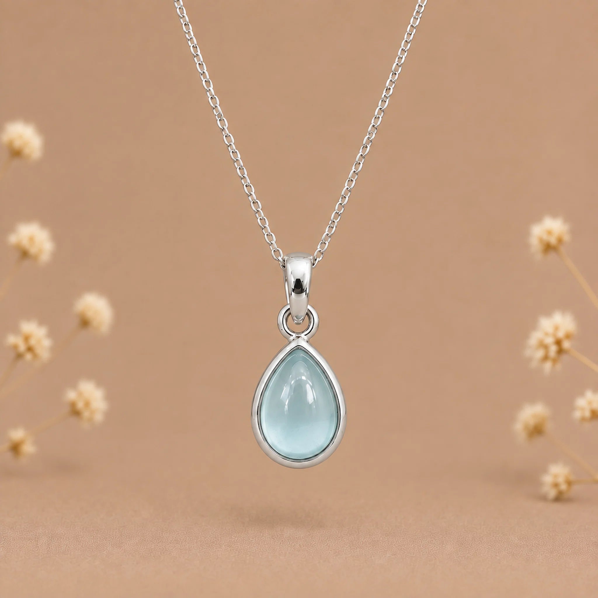sterling silver march birthstone necklace featuring a pear-shaped bezel set cabochon natural aquamarine pendant