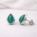 may birthstone Teardrop-shaped green natural emerald gemstone stud earrings with sterling silver settings on a white background
