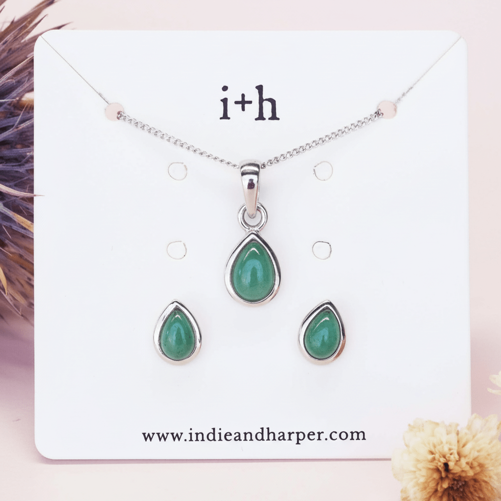 Jewelry set with green teardrop pendants on a branded card with 'i+h' logo.