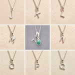 Collage of silver necklaces with letters J to Q on a beige background, as personalised initial pendant options to add to a May Birthstone Emerald Necklace.