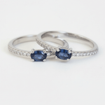 Two silver rings with blue gemstones on a white background