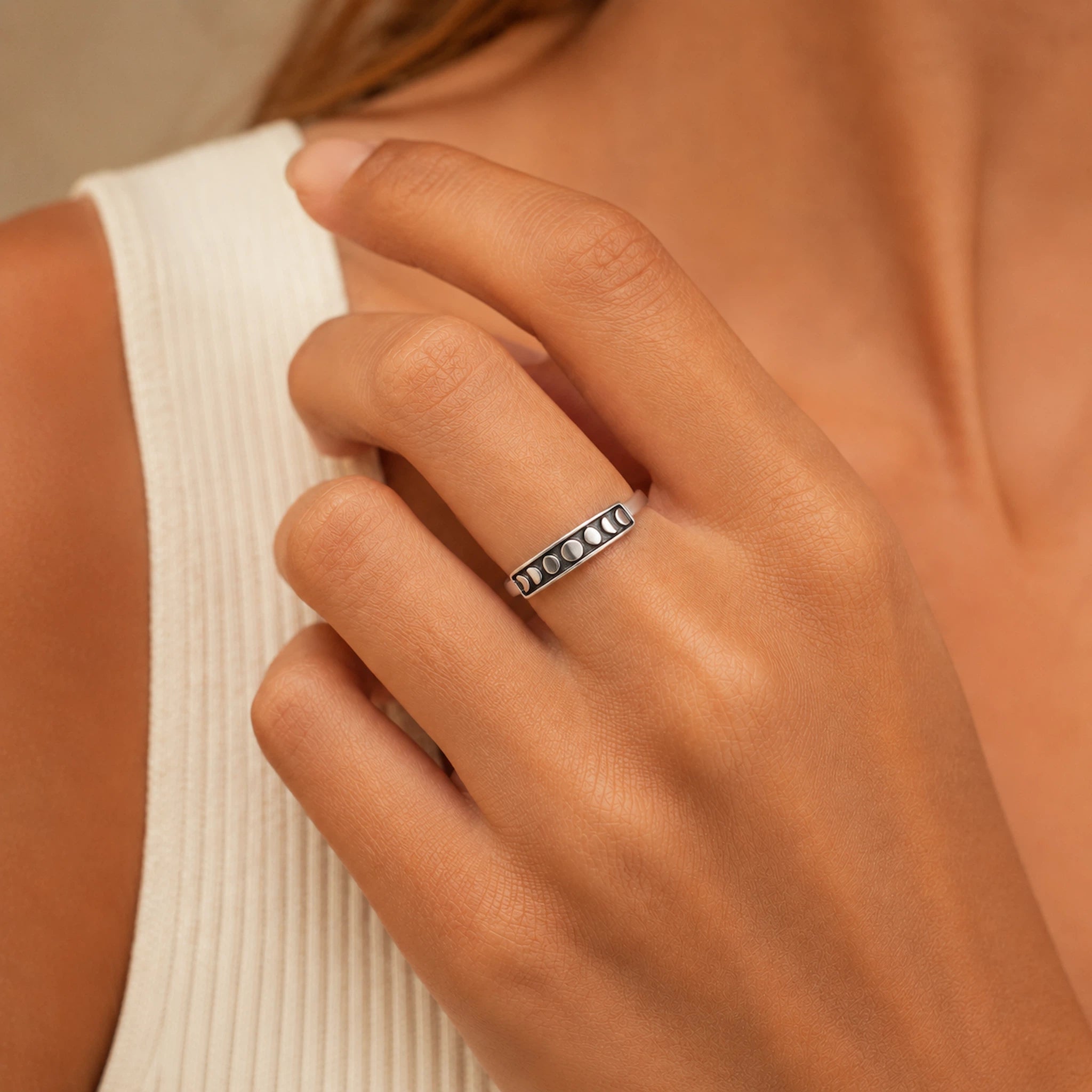 sterling silver oxidised moon phase band ring being worn by a person wearing a white top