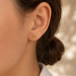 woman with dark brown hair wearing a silver stud claw set faceted natural citrine stud earrings