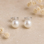 Sterling Silver Classic 7mm Natural Freshwater Pearl Stud Earrings on a light background.