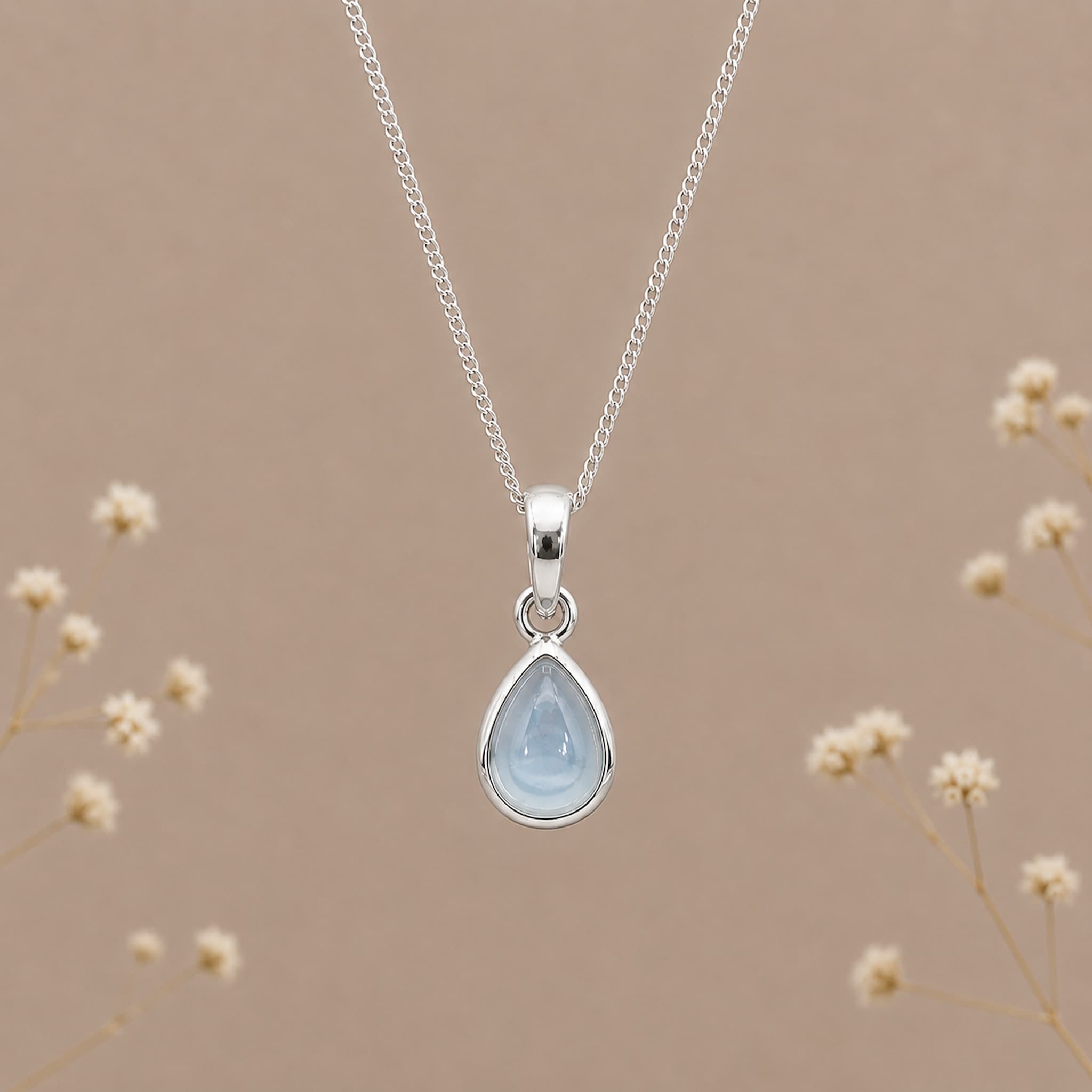 sterling silver november birthstone topaz necklace with a dainty pear-shaped cabochon bezel set natural light blue topaz gemstone hanging