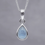Sterling Silver November birthstone necklace with a pear-shaped natural blue topaz gemstone on a grey background