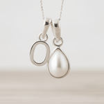 Sterling Silver necklace with O initial pendant with a teardrop-shaped pearl pendant on a light background