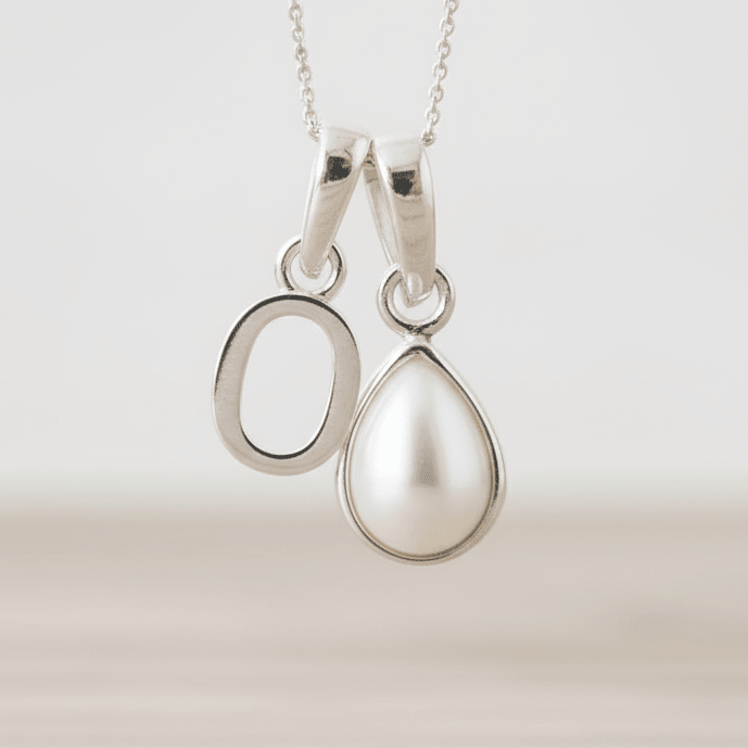 Sterling Silver necklace with O initial pendant with a teardrop-shaped pearl pendant on a light background