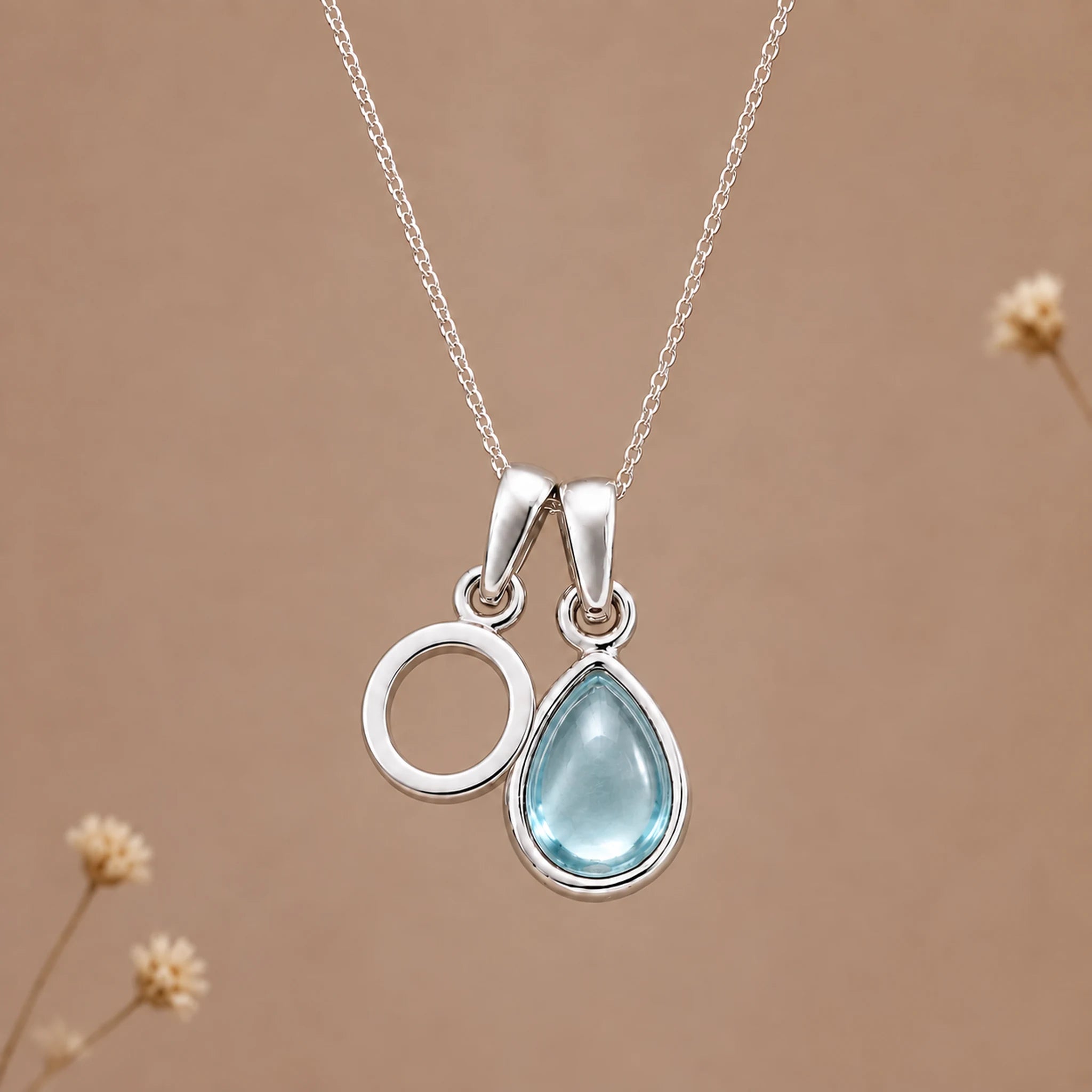 Sterling silver O initial necklace with pale blue March aquamarine in a polished teardrop bezel