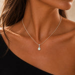 sterling silver october birthstone necklace featuring a teardrop bezel-set natural opal pendant worn on a model