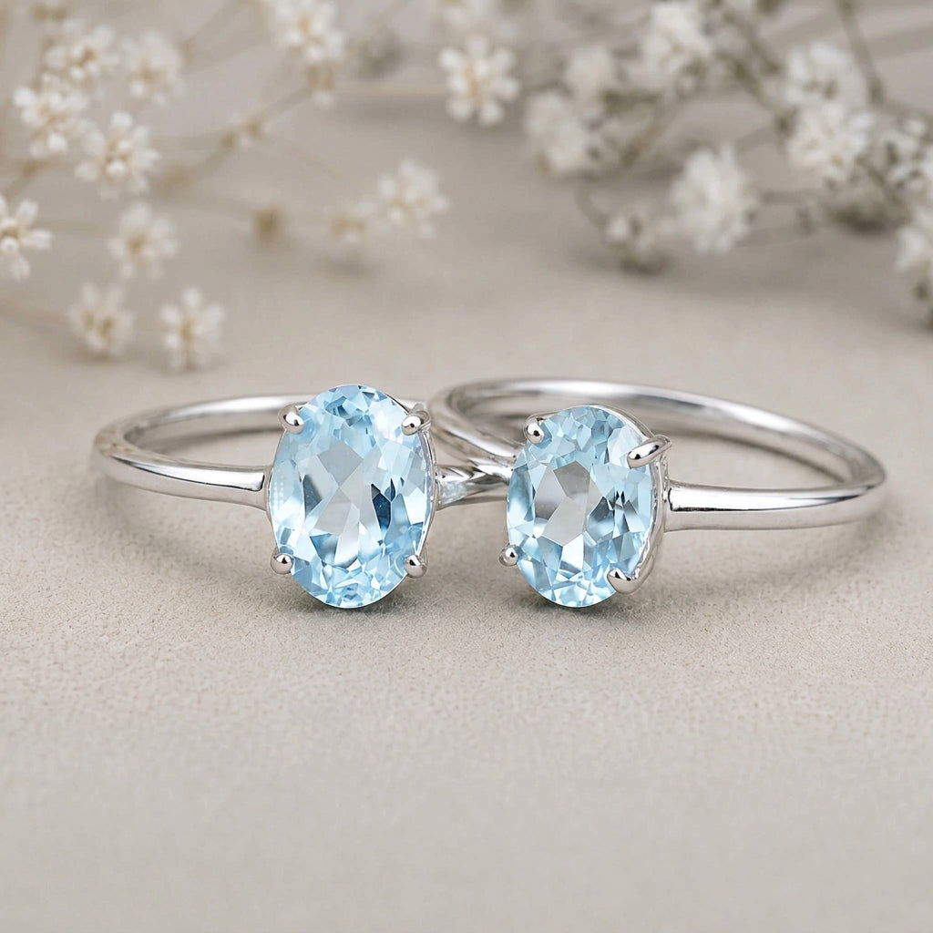 Sterling silver blue topaz rings with faceted oval stones on a light surface