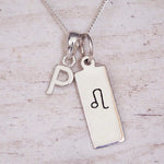 sterling silver initial p leo zodiac star sign pendant necklace against a light wooden background