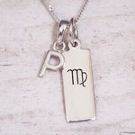 sterling silver initial p virgo zodiac star sign pendant necklace against a light wooden background