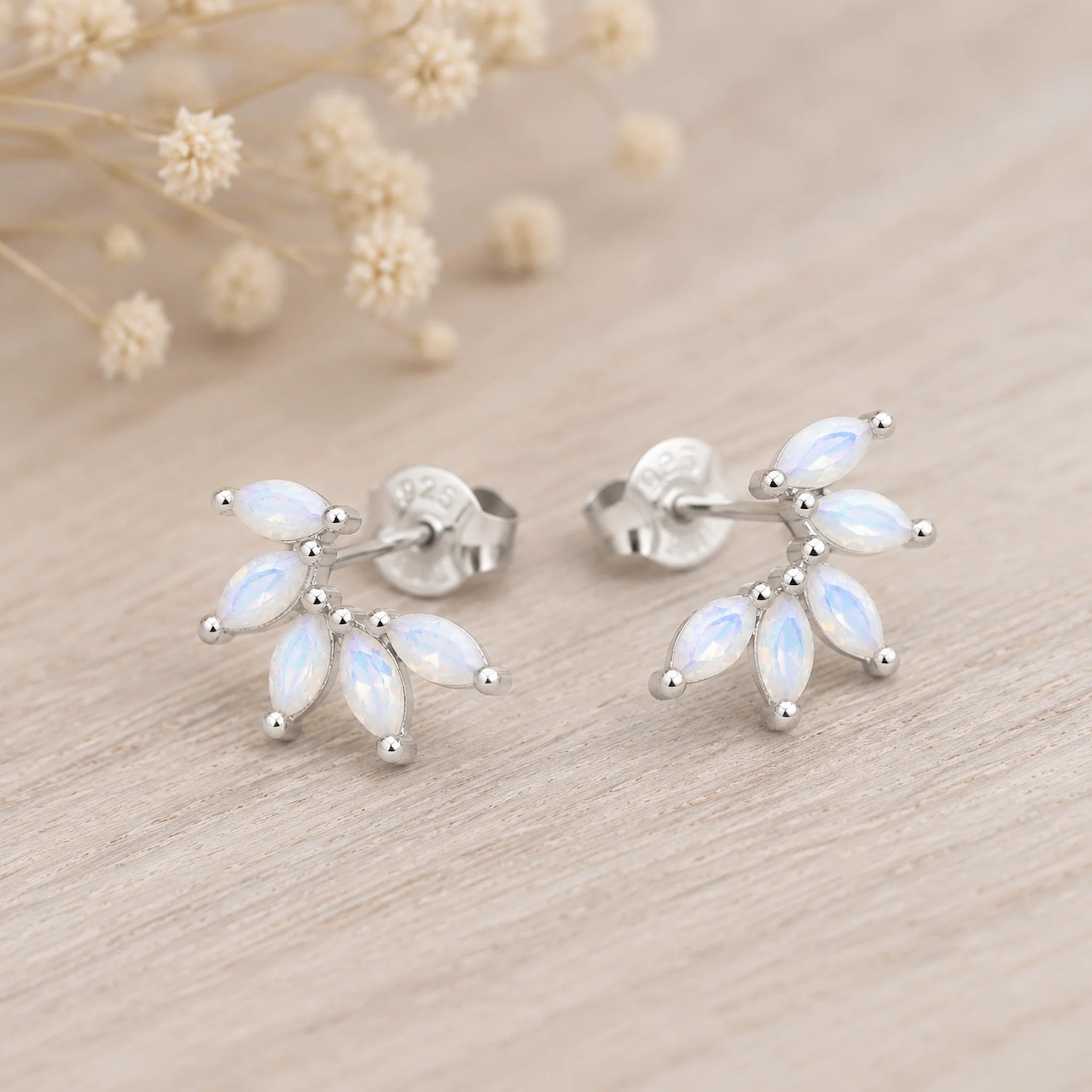 pair of sterling silver stud earrings with marquise shaped czs on a light surface