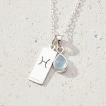 Sterling Silver necklace with a March Birthstone aquamarine pendant and a Pisces Zodiac Star Sign on a white background