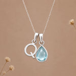 Sterling silver Q initial necklace with pale blue March aquamarine in a polished teardrop bezel