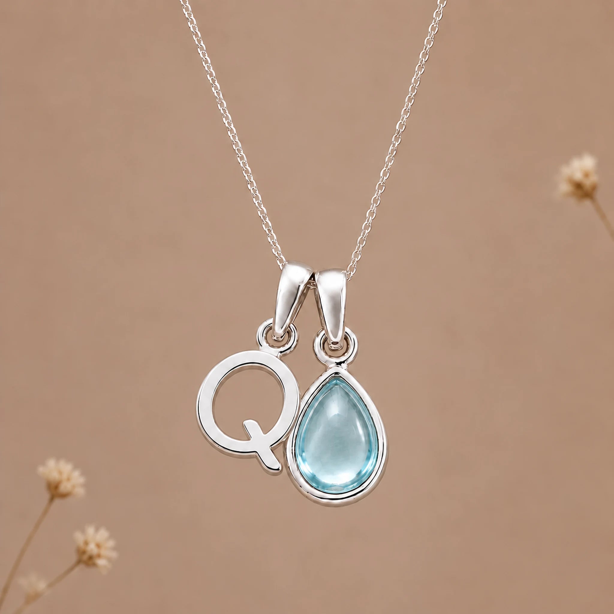 Sterling silver Q initial necklace with pale blue March aquamarine in a polished teardrop bezel