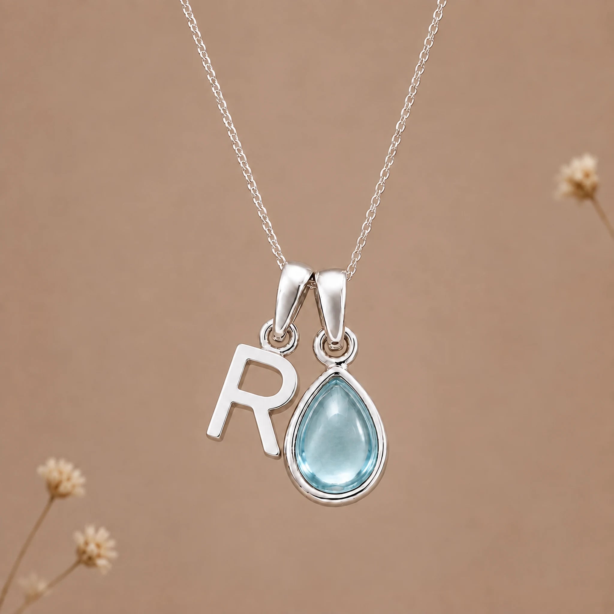 Sterling silver R initial necklace with pale blue March aquamarine in a polished teardrop bezel