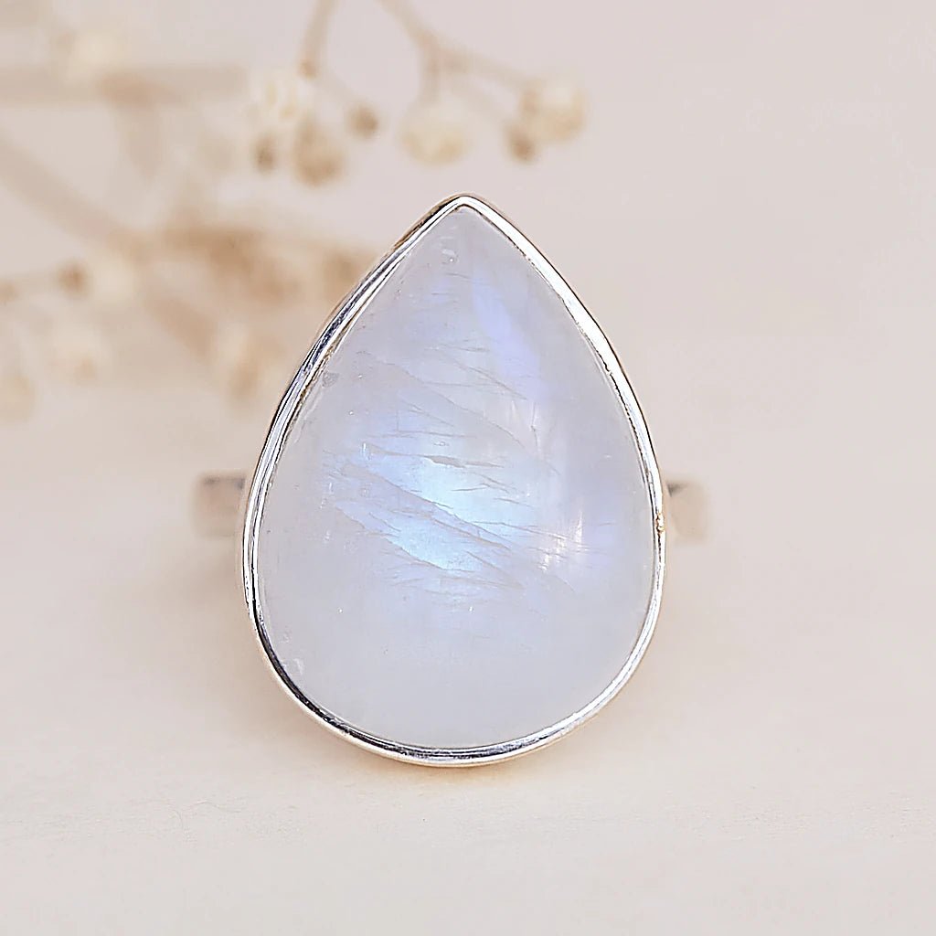 Teardrop-shaped moonstone ring with silver setting on a neutral background