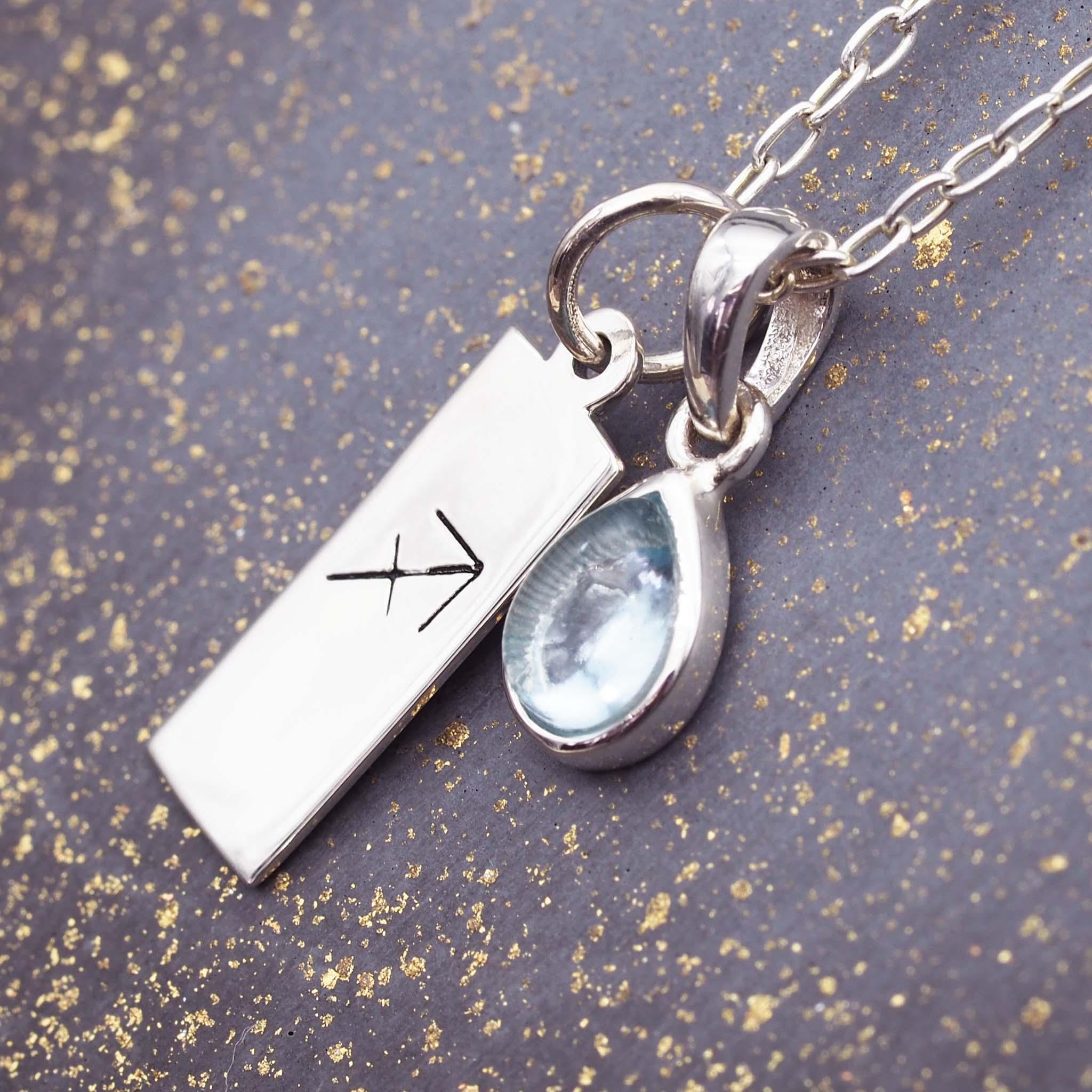 Sterling silver Necklace with a Sagittarius zodiac pendant and a November Birthstone blue topaz gemstone on a grey background