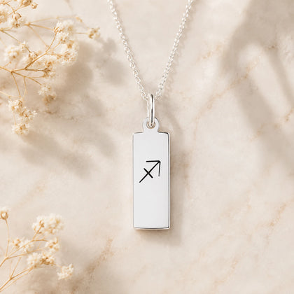 dainty sterling silver fine chain necklace with a rectangle pendant engraved with sagittarius zodiac line glyph symbol hanging.