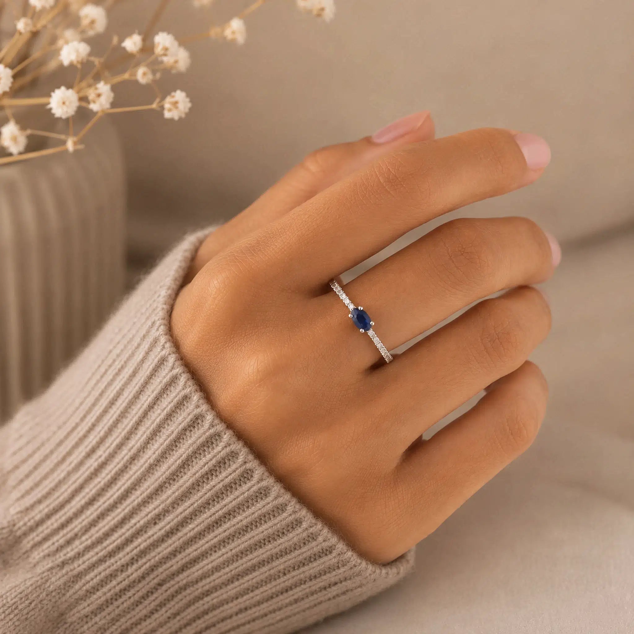 Dainty sterling silver stacking ring featuring a faceted oval blue sapphire and clear cubic zirconia accents.