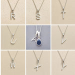 Collection of silver letter pendants R to Y on beige backgrounds as initial options for September Birthstone Sapphire Necklace.
