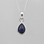 September Birthstone Natural Sapphire Necklace - A silver teardrop pendant necklace featuring a polished dark blue lapis lazuli stone, shown against a neutral gray background.