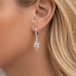 Silver snake-shaped earring worn by a person with blonde hair.
