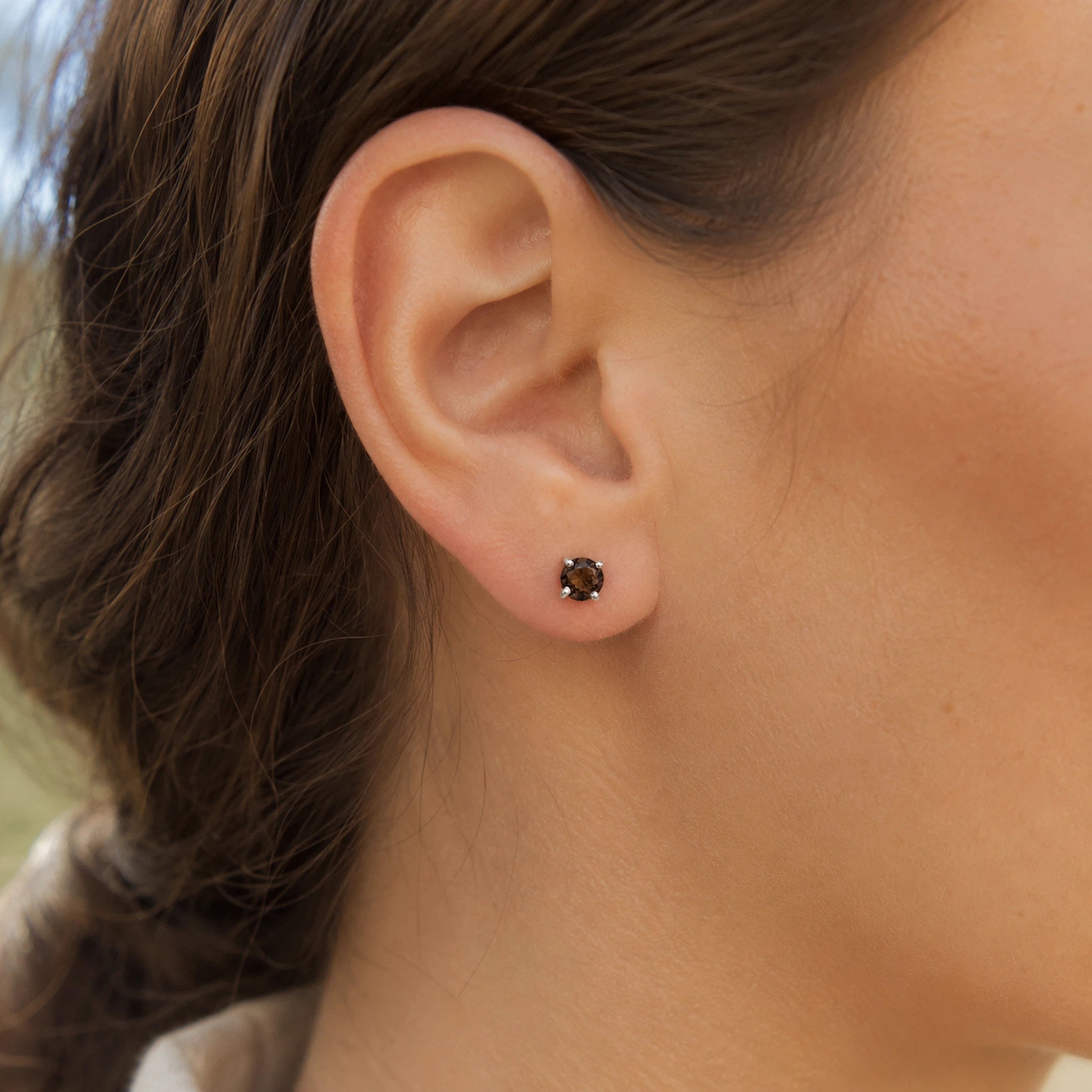 woman wearing a sterling silver smoky quartz stud earring