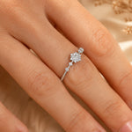close up of finger wearing a sterling silver dainty ring with cubic zirconia snowflake design