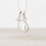 Sterling Silver necklace with a T initial pendant with a teardrop pearl pendant on a white background