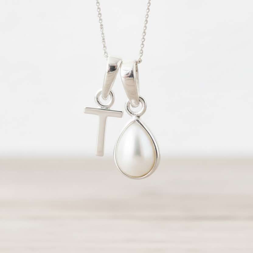 Sterling Silver necklace with a T initial pendant with a teardrop pearl pendant on a white background