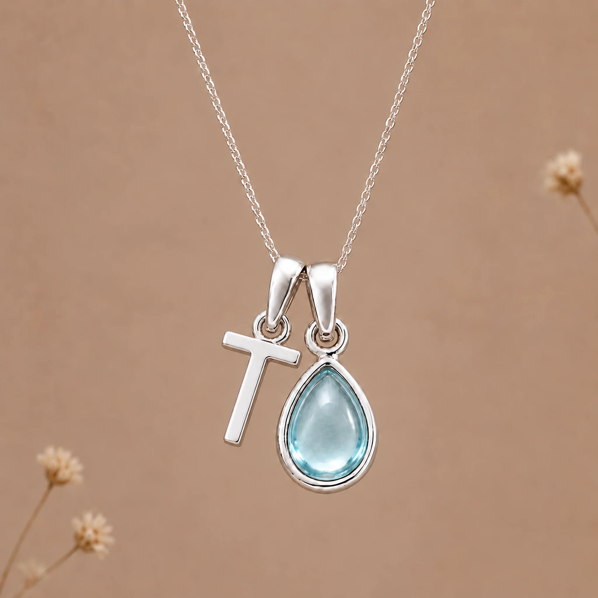 Sterling silver T initial necklace with pale blue March aquamarine in a polished teardrop bezel