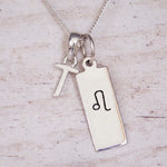 sterling silver initial t leo zodiac star sign pendant necklace against a light wooden background