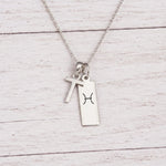 sterling silver T initial Pisces Necklace on a fine silver chain against a light wooden background
