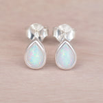 pair of sterling silver stud earrings with teardrop bezel set cabochon lab-grown white opals