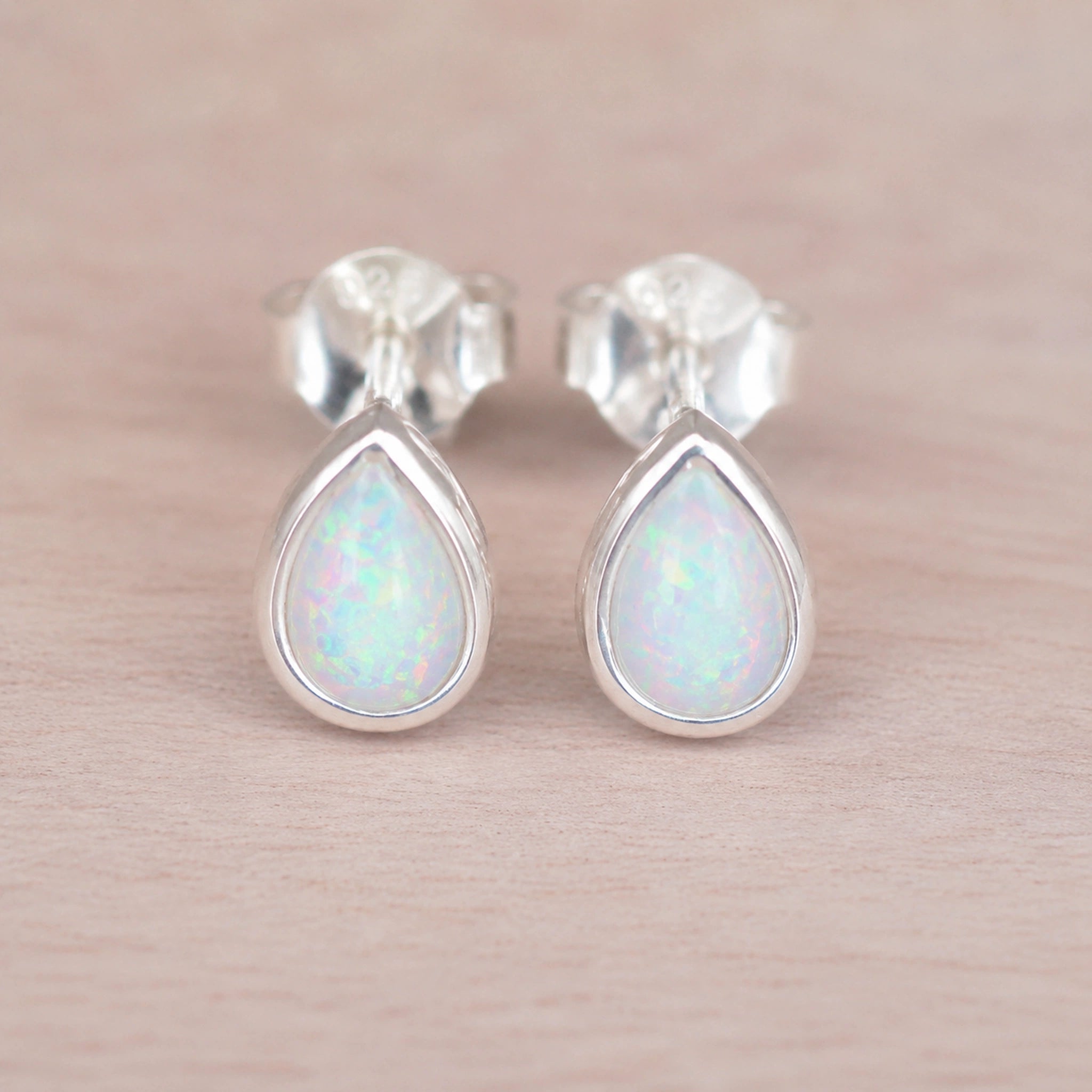 pair of sterling silver stud earrings with teardrop bezel set cabochon lab-grown white opals