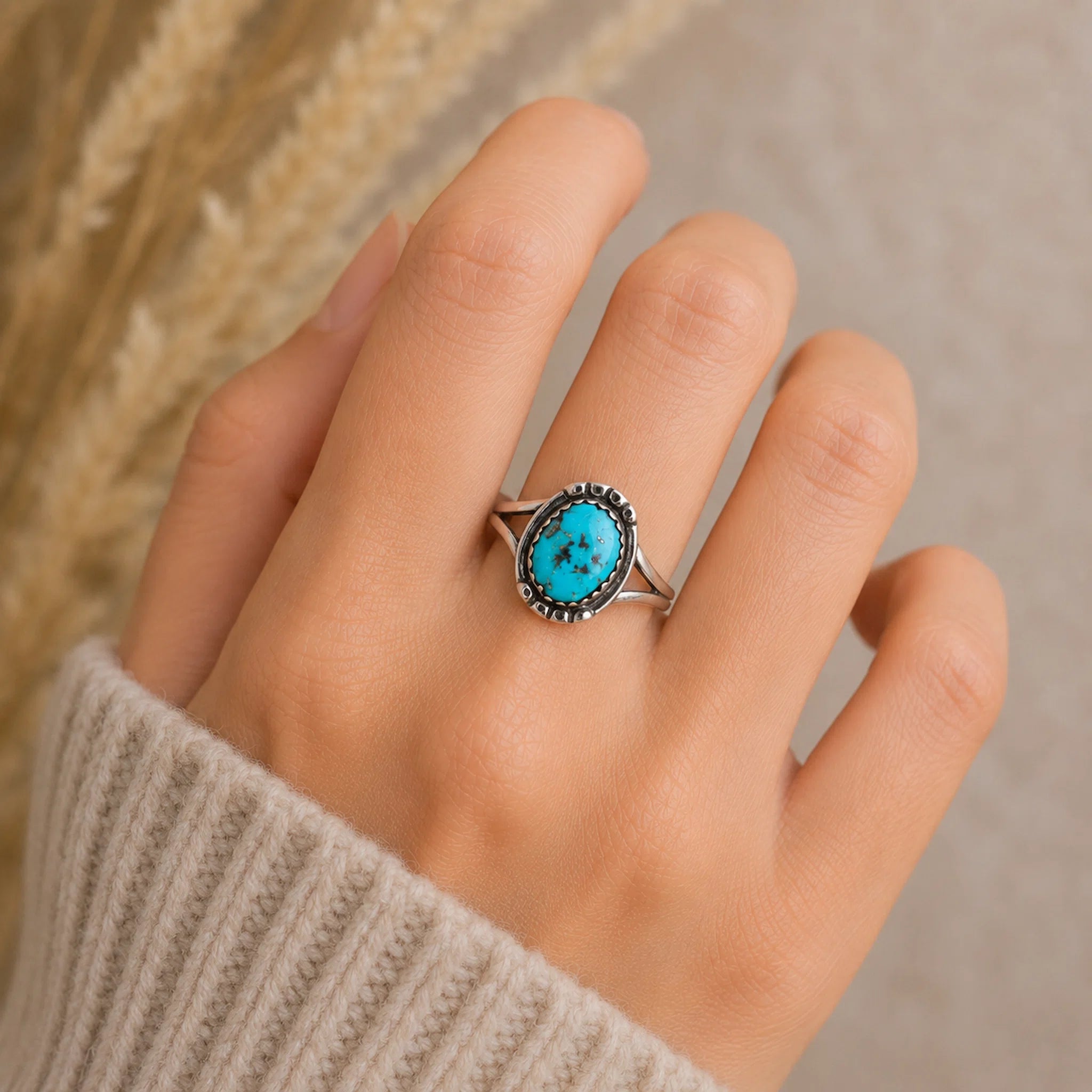 hand wearing a sterling silver oxidised ring with a natural turquoise stone, hand crafted by navajo artisans.