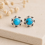 pair of sterling silver stud earrings with bezel set turquoise stones